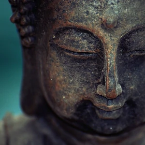 S'éveiller par les sons de guérison - Visage de Bouddha souriant et yeux clos sur fond vert